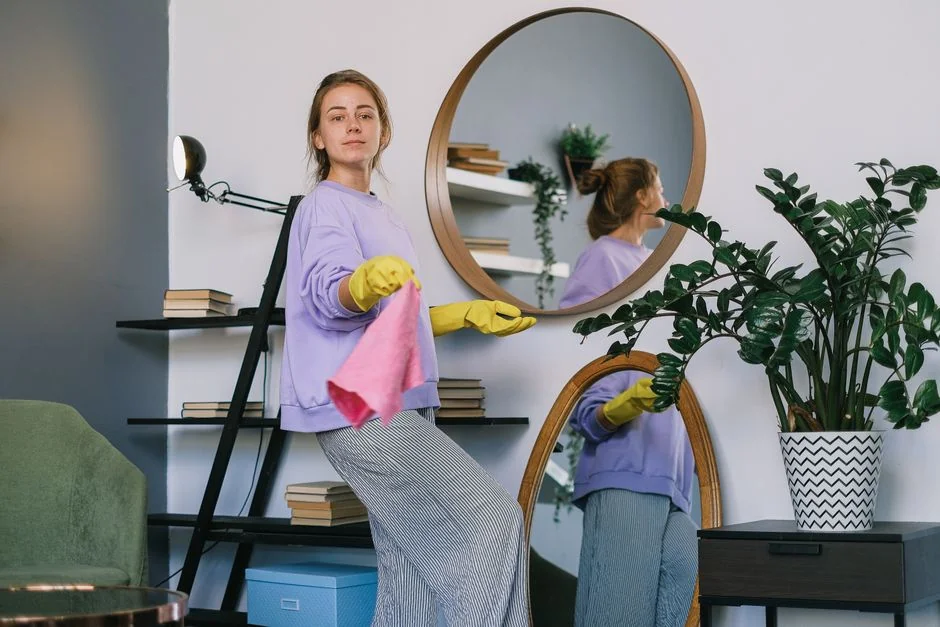 gallery-04 A woman is wrapping a sofa in plastic in a bright living room as part of a move.